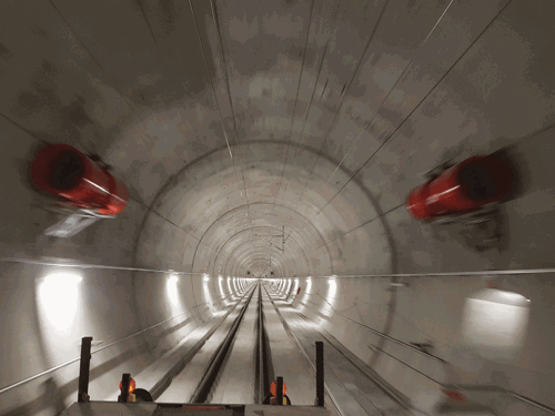 A photo taken inside the empty service tunnel showing two red jet fans