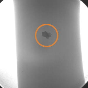 An x ray of an impeller blade with a an orange circle highlighting an imperfection