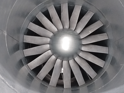 A photo taken inside the casing of an axial fan showing the hub and the impeller which has 18 blades